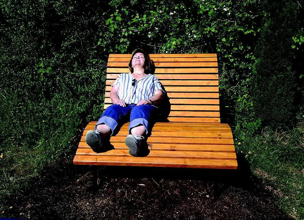 older white woman lounging in a chair in the sun reducing stress